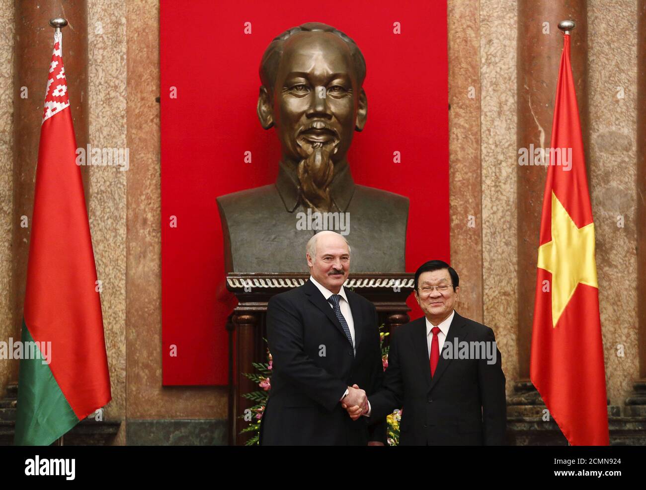 El presidente bielorruso Alexander Lukashenko (L) hace una foto con su  homólogo vietnamita Truong tan Sang frente a una estatua del difunto líder  revolucionario vietnamita Ho Chi Minh en el Palacio Presidencial