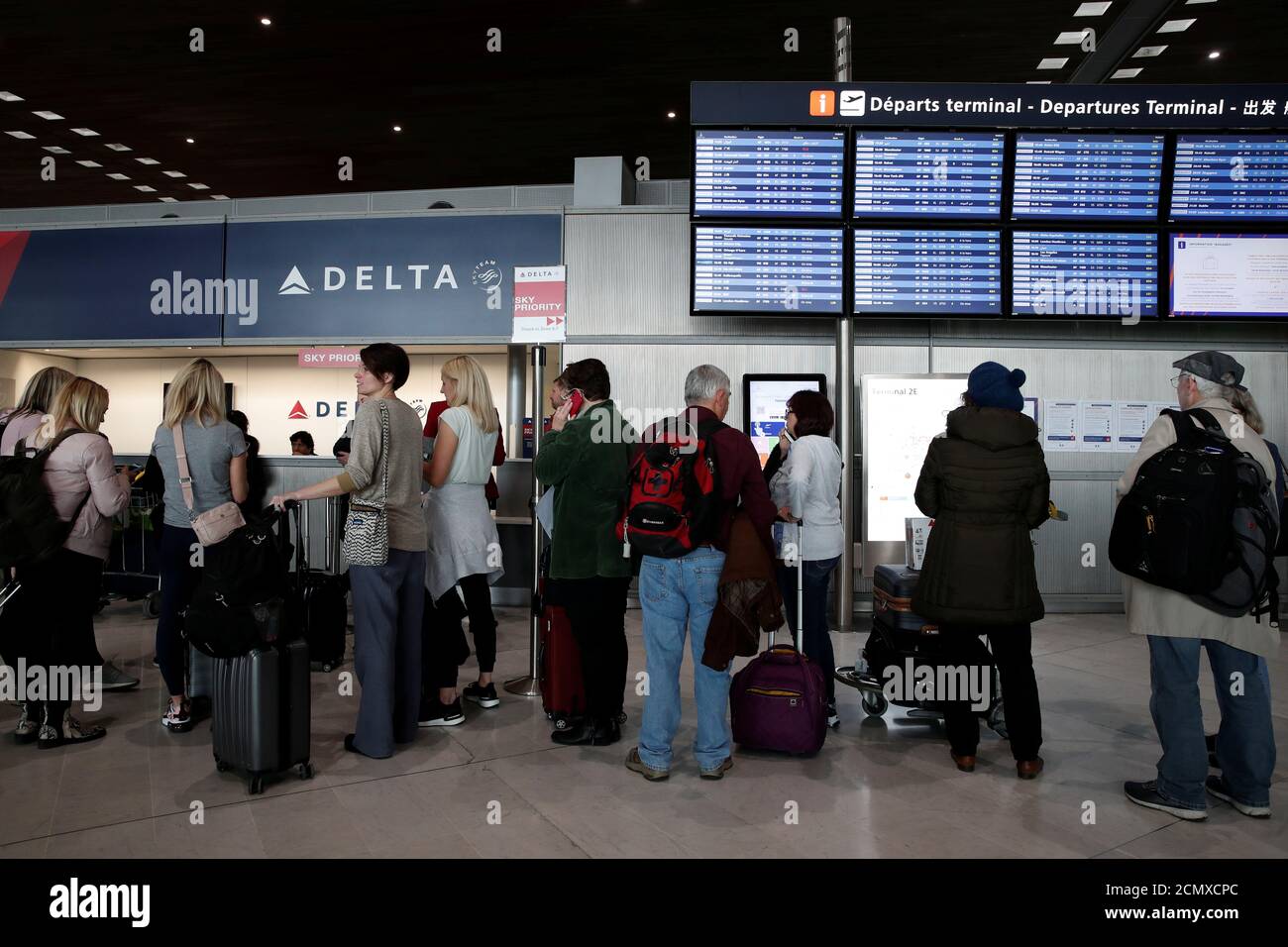 Las personas se alinean en el mostrador de venta de billetes de Delta Air  Lines dentro de la Terminal 2E en el aeropuerto Charles de Gaulle de París  en Roissy, después de