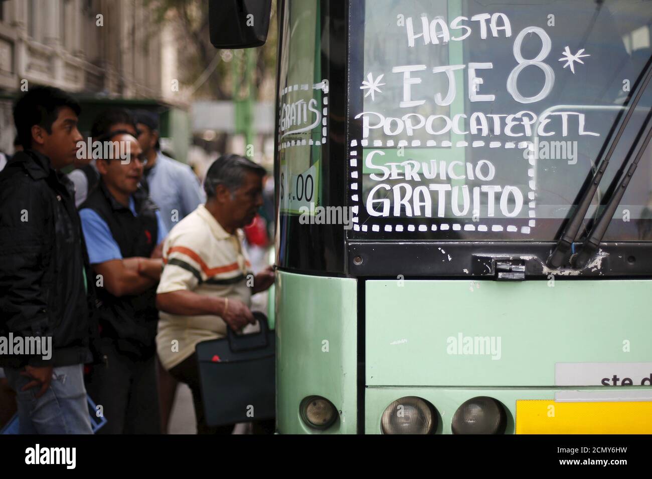 Los pasajeros se embarcará en un autobús eléctrico durante un día libre de transporte público en la Ciudad de México, 16 de marzo de 2016. El gobierno de la Ciudad de México ordenó restricciones de tráfico y recomendó a la gente permanecer en el interior debido a la grave contaminación del aire, emitiendo su segunda alerta más alta para los niveles de ozono por primera vez en 13 años. La señal dice, 'hasta el eje 8, Popocatepetl. Servicio gratuito". REUTERS/Edgard Garrido Foto de stock