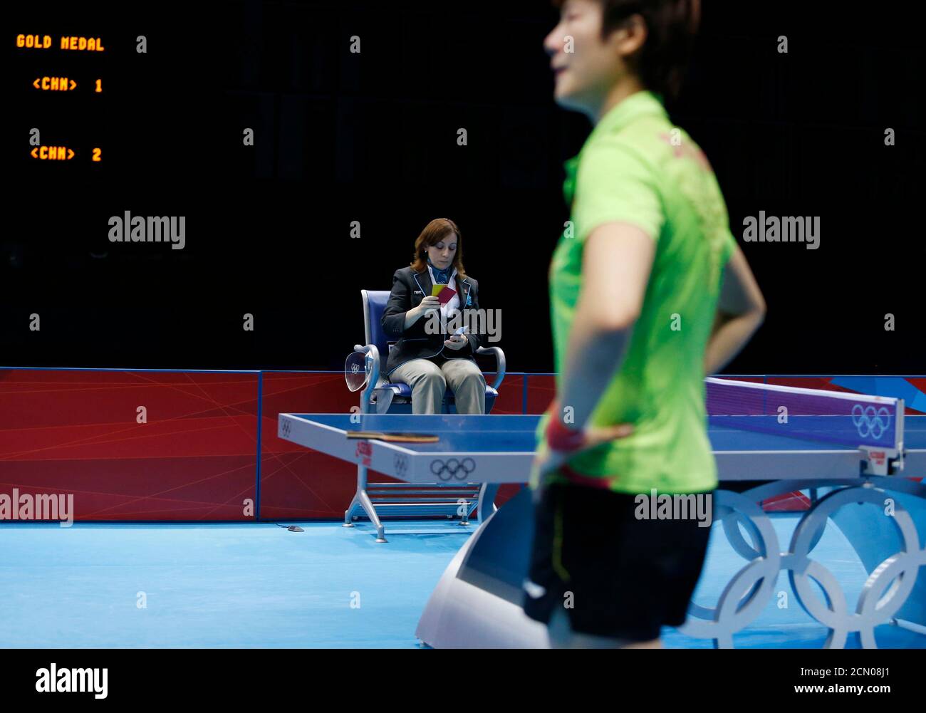 La China Ding Ning reacciona como la árbitro Paola Bongelli de Italia hace  un llamado a su servicio en el partido de tenis de mesa de medalla de oro  de sus mujeres