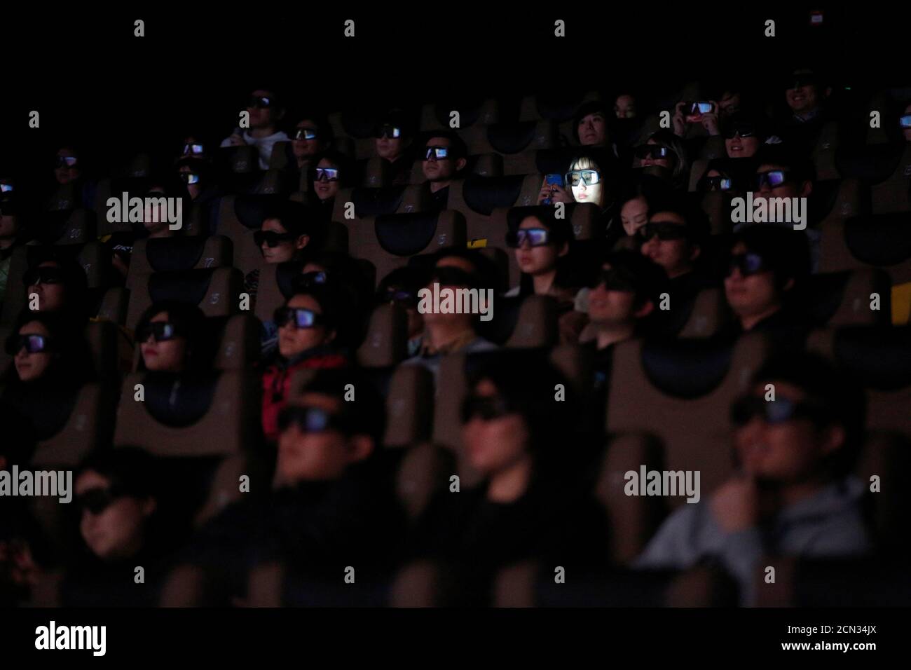 La gente que lleva gafas 3D ve la película 