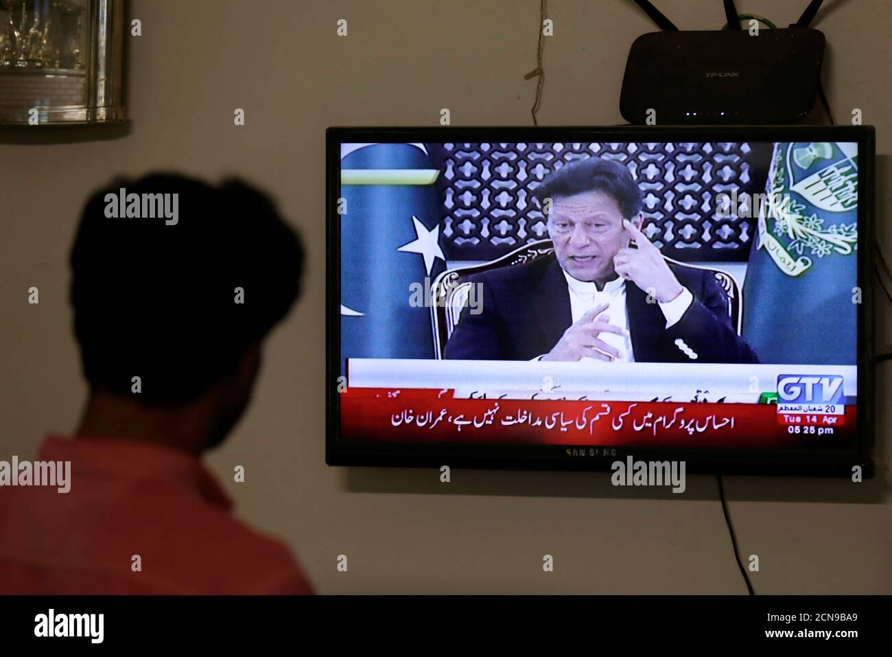 Una pantalla de televisión muestra al primer Ministro de Pakistán Imran Khan, anunciando la extensión de un bloqueo en todo el país durante dos semanas, debido a la propagación continua de la enfermedad del coronavirus (COVID-19), en Karachi, Pakistán, el 14 de abril de 2020. REUTERS/Akhtar Soomro Foto de stock
