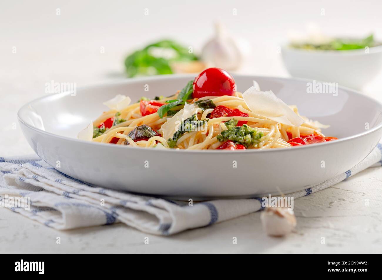Pasta italiana con salsa de pesto, albahaca fresca y tomates cherry. Foto de stock
