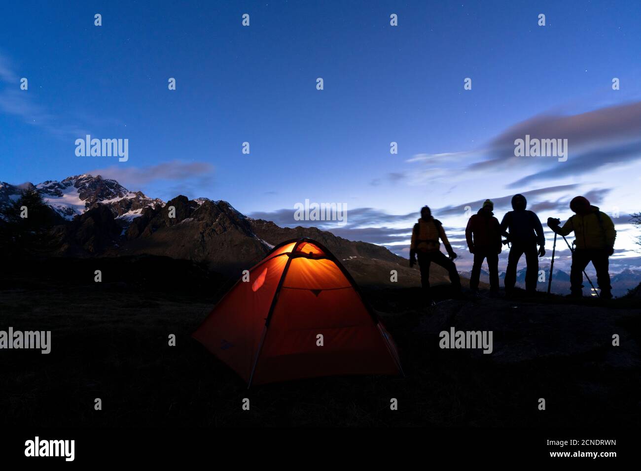 Excursionistas acampando con carpa fotografiando Monte Disgrazia por la noche, Valmalenco, provincia de Sondrio, Valtellina, Lombardía, Italia, Europa Foto de stock