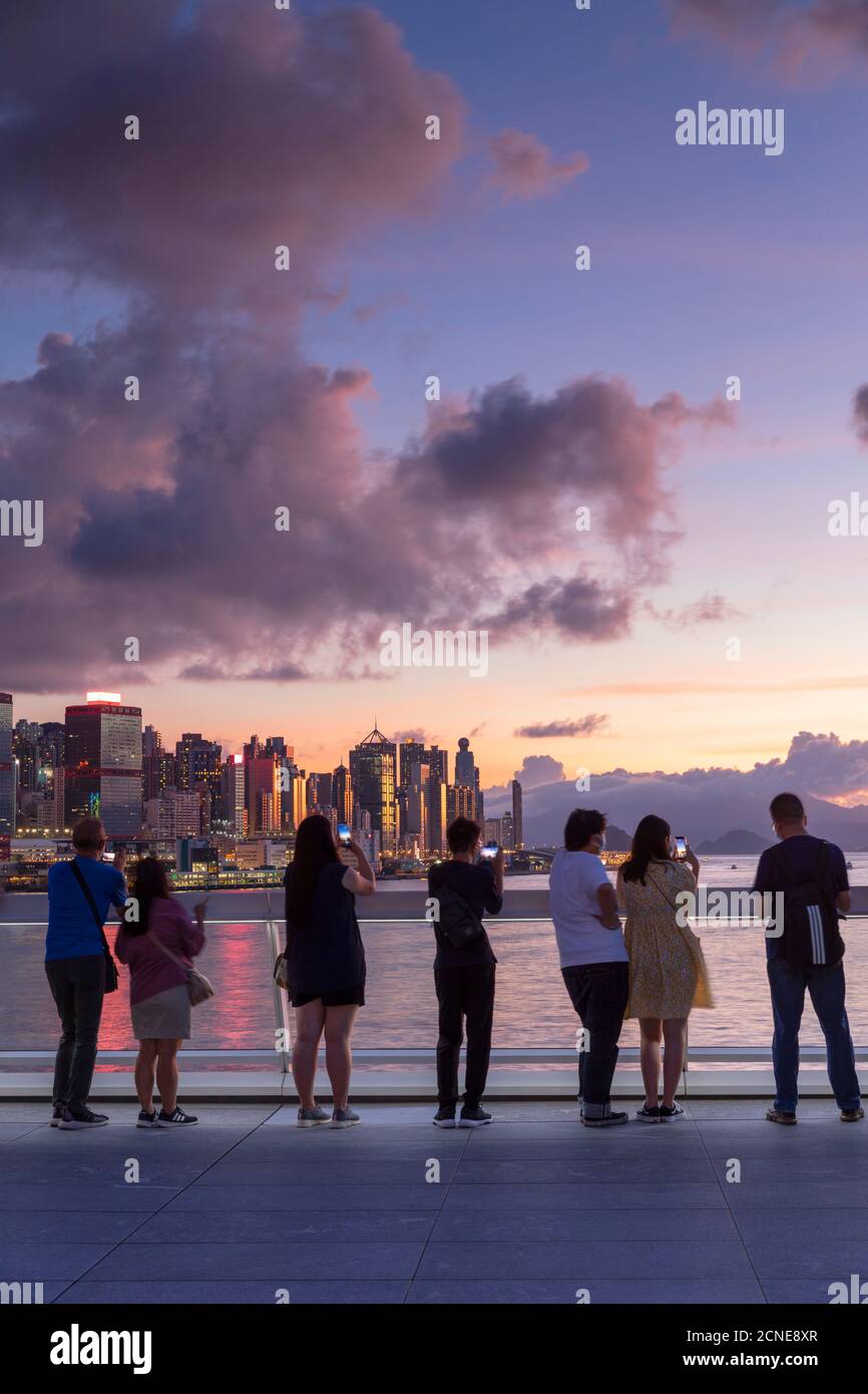 Gente viendo la puesta de sol desde Harbour City, Hong Kong, China, Asia Foto de stock