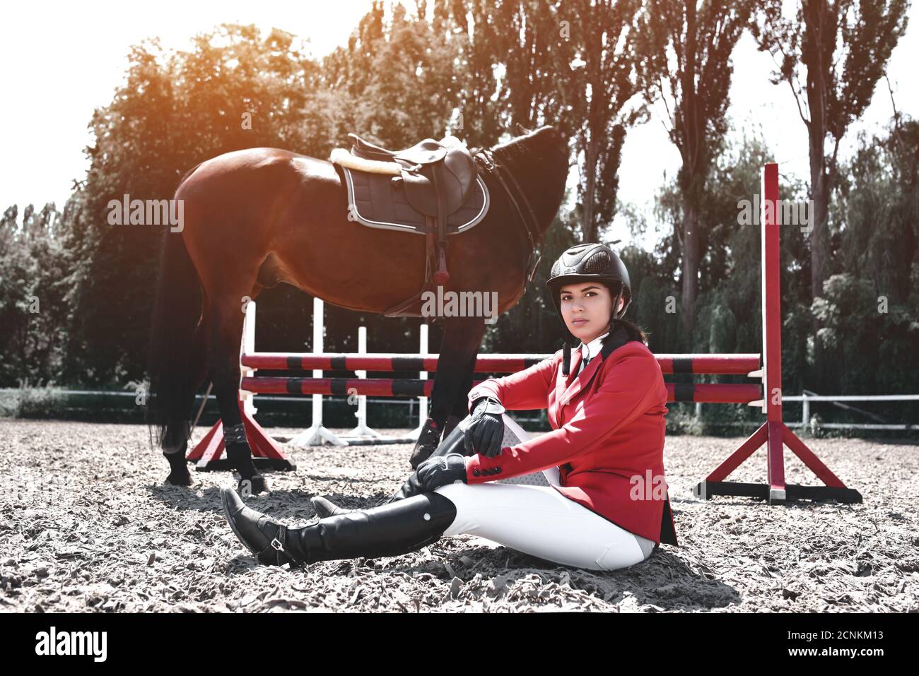Jinete joven serio Chica y su caballo posando después del entrenamiento. Ama a los animales y pasa su tiempo con alegría en su entorno Foto de stock