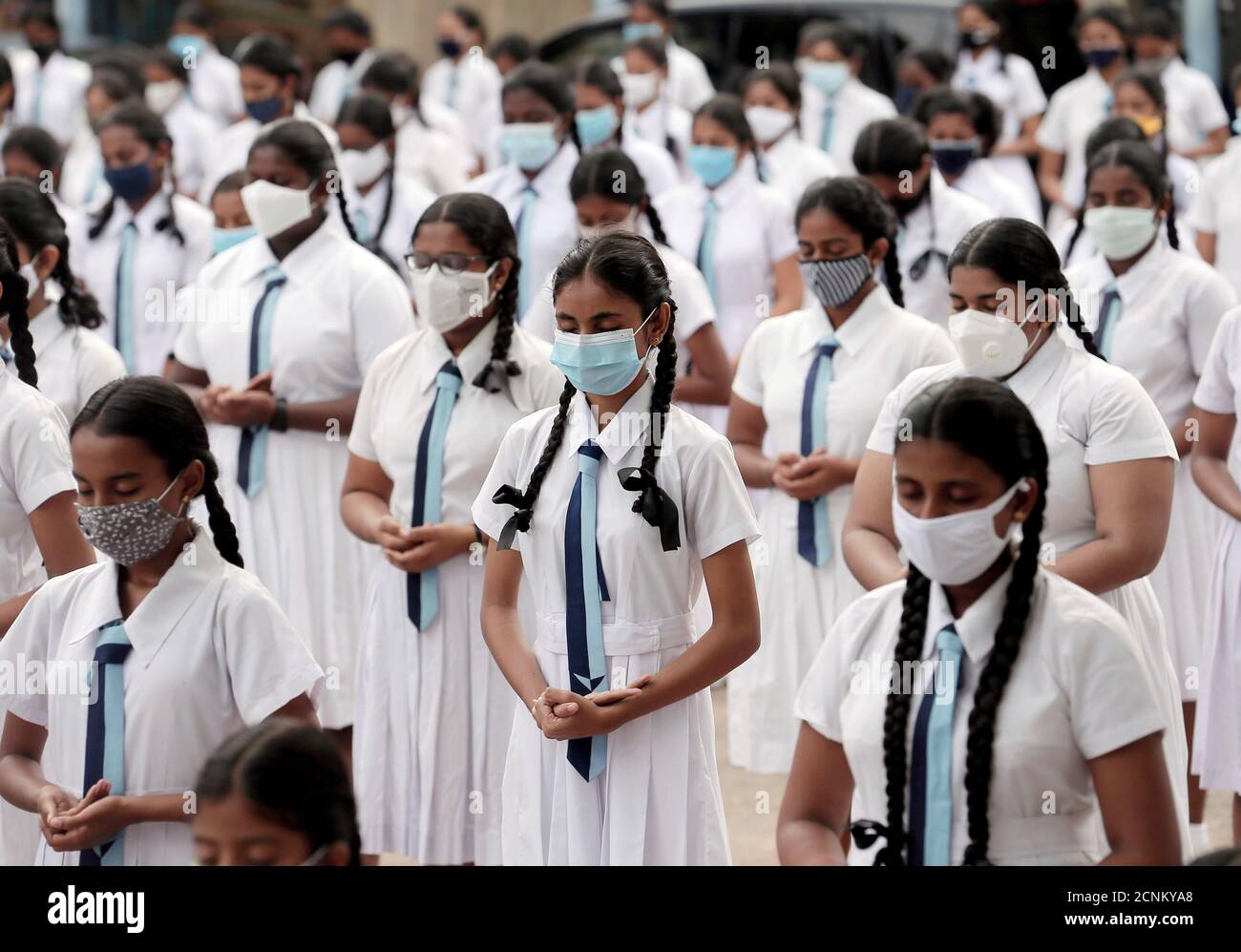 Los estudiantes que usan máscaras protectoras asisten a una meditación para la relajación mental antes del comienzo del primer día en el colegio Vidyakara, que se reabrió después de casi dos meses de bloqueo en medio de preocupaciones sobre la propagación de la enfermedad del coronavirus (COVID-19), en Colombo, Sri Lanka, 6 de julio de 2020. REUTERS/Dinuka Liyanawatte Foto de stock