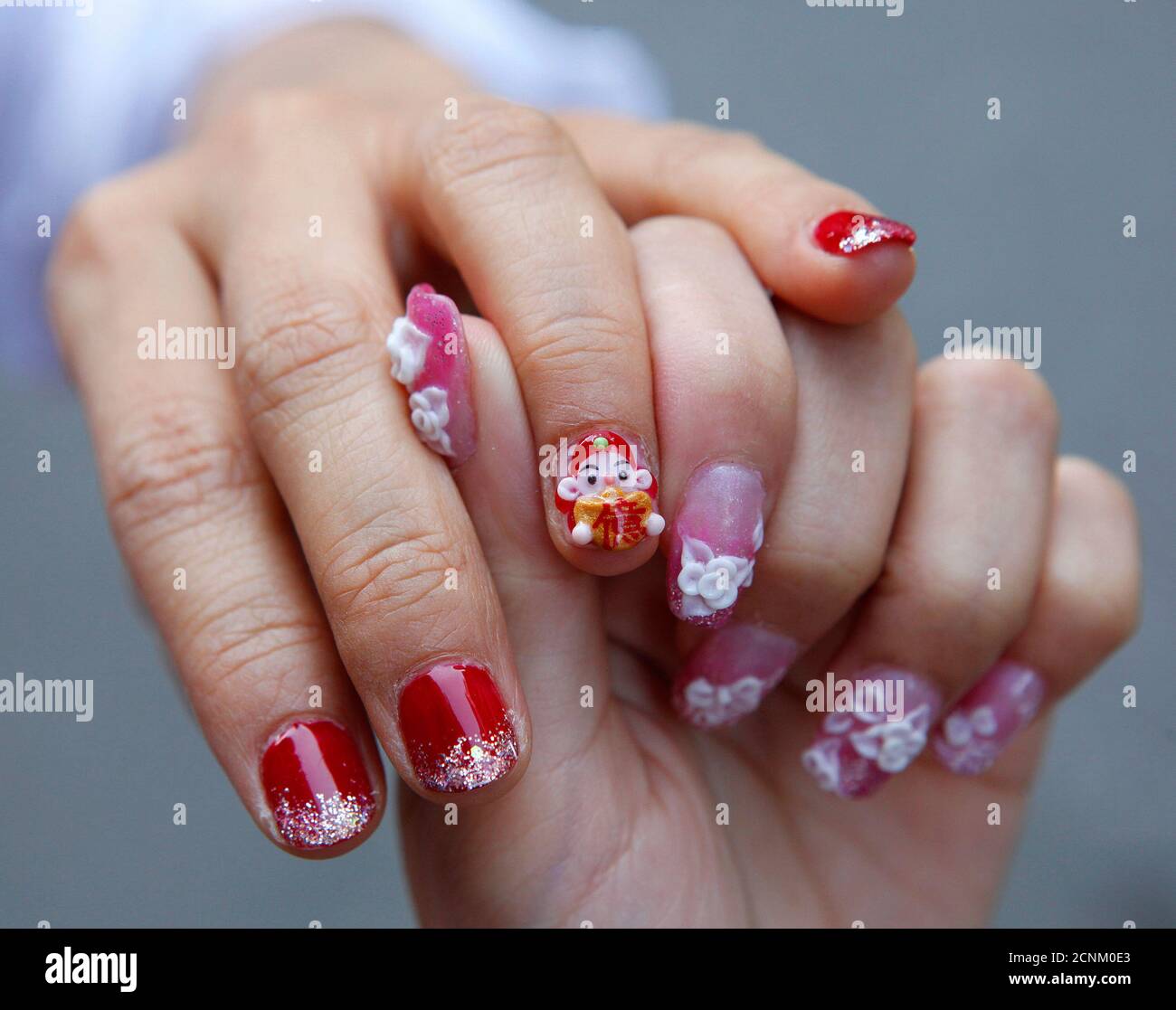 A woman gets a manicure with a mini figurine of the Chinese "God of Wealth"  pasted on her nail before upcoming Chinese Lunar New Year celebrations in  Taipei February 11, 2010. The "