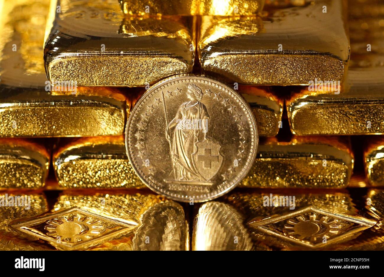 Gold bars and a Swiss Franc coin are seen in this illustration picture  taken at the Austrian Gold and Silver Separating Plant 'Oegussa' in Vienna  November 7, 2014. A vote in favour