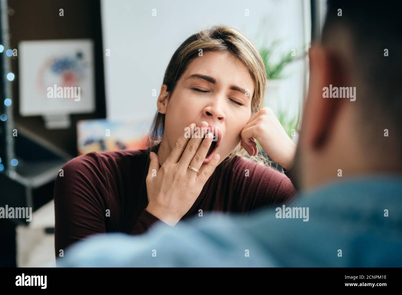 Mujer bostezando durante una conversación aburrida con la pareja Foto de stock