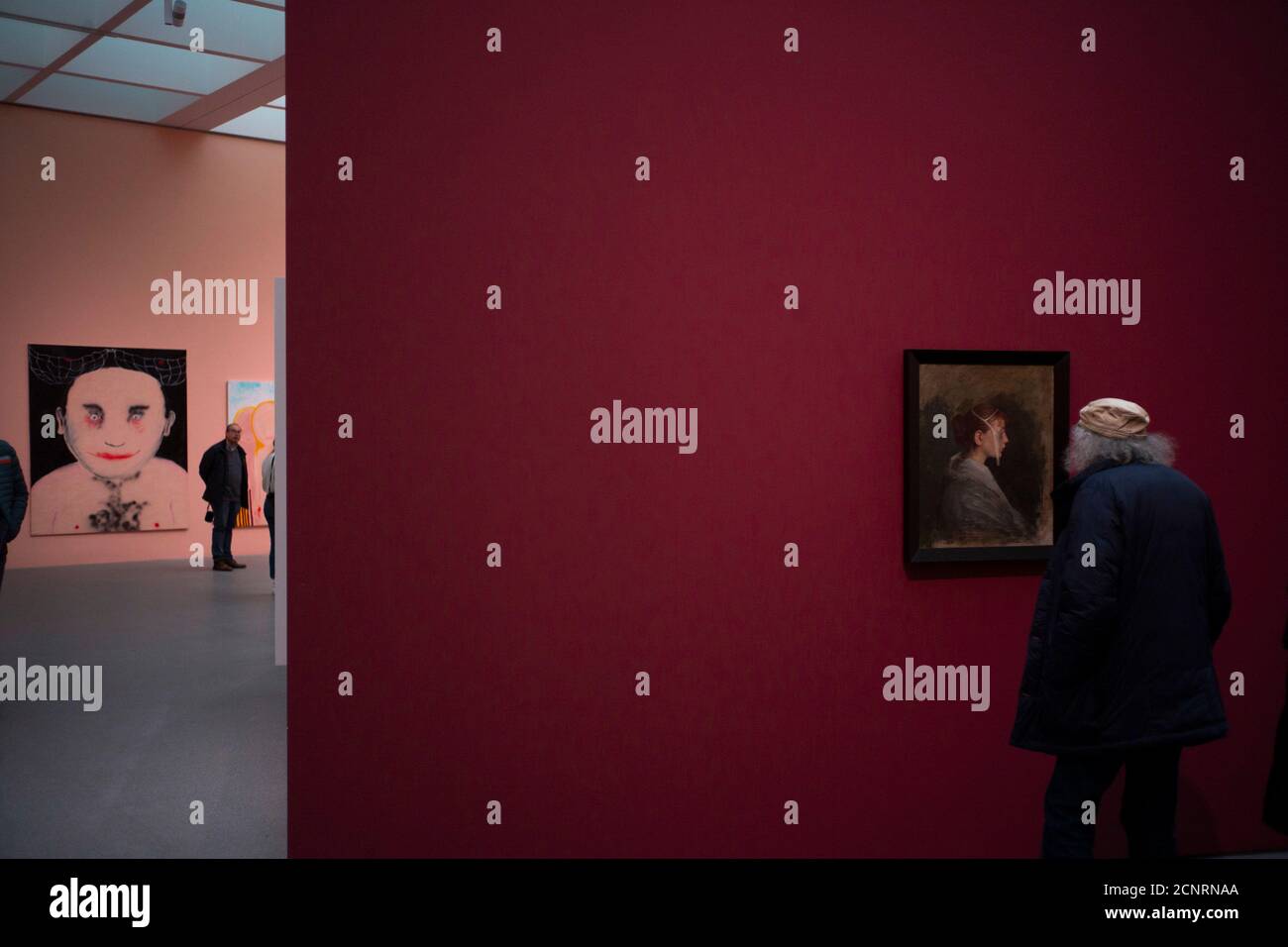 Pinakothek der Moderne, sentimientos de exposición, hombre con gorra y pelo gris mira pinturas, arte moderno, Munich, Foto de stock