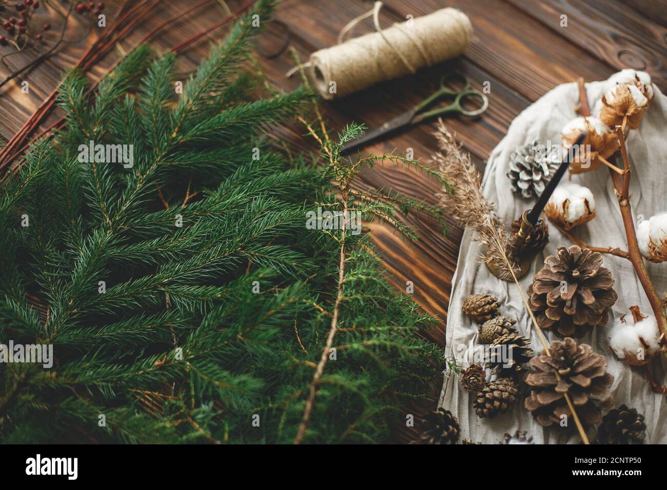 Ramas de árbol de Navidad y decoraciones para hacer guirnalda de Navidad  rústica en casa. Ramas naturales de abeto, conos de pino, hierbas, hilo,  algodón y tijera Fotografía de stock - Alamy