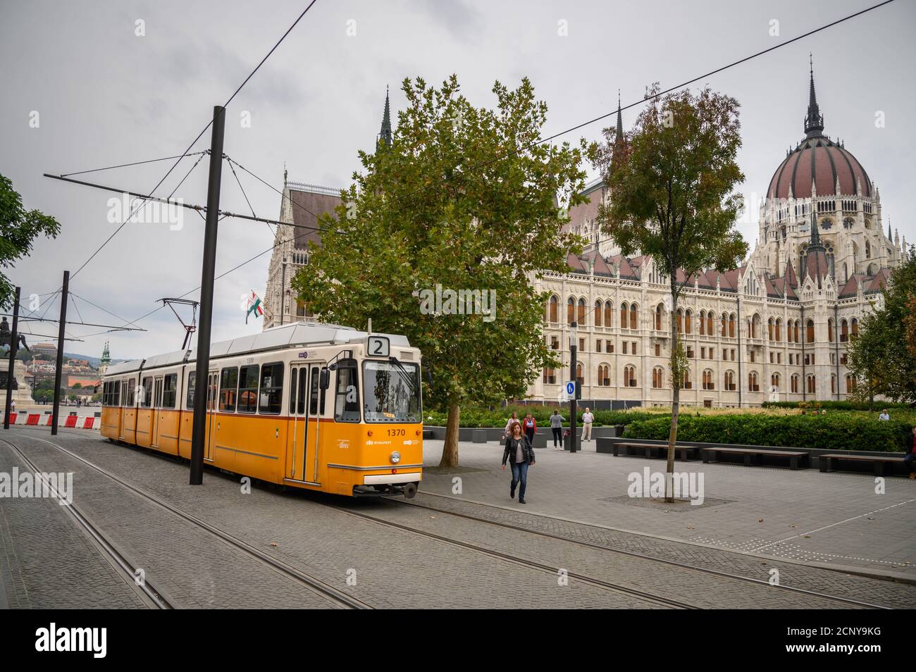 BUDAPEST, HUNGRÍA - 25 DE SEPTIEMBRE DE 2019. El tranvía amarillo pasa frente al edificio del Parlamento húngaro. Foto de stock