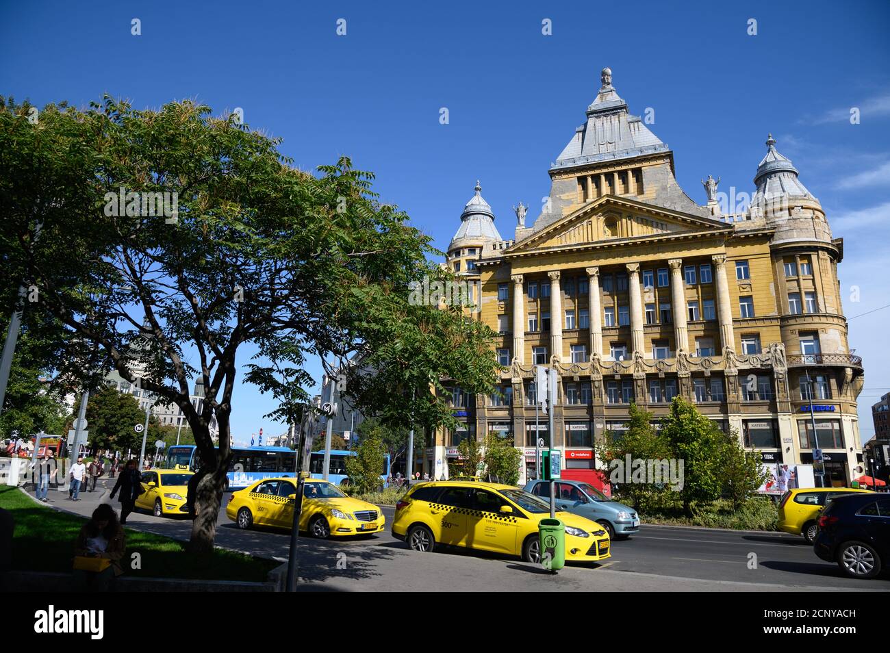 BUDAPEST-HUNGRÍA- 26 DE SEPTIEMBRE de 2019: Taxis amarillos que pasan frente al antiguo edificio de Katedra nyelviskola en Budapest, la capital de Hungría Foto de stock