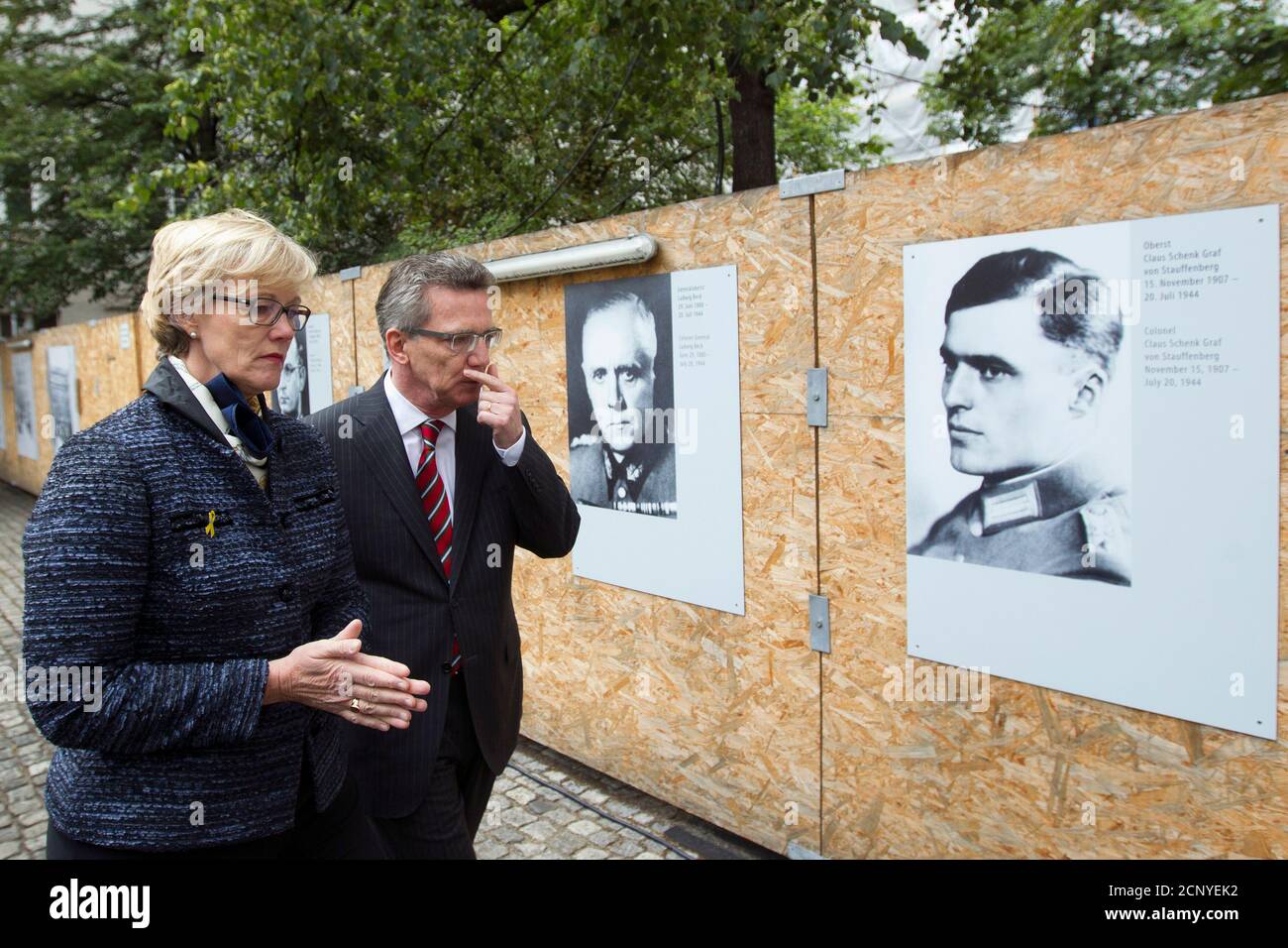 German Defence Minister Thomas de Maiziere (2nd L) and his wife Martina walk past portraits of Ludwig Beck (2nd R) and Claus von Stauffenberg who conspired to overthrow Adolf Hitler in the '