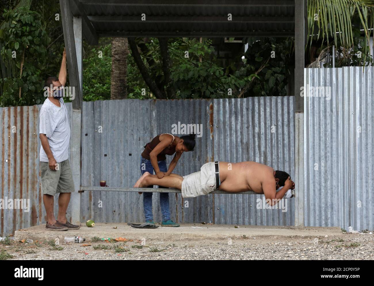 Una mujer da un masaje a un camionero en la frontera entre Costa Rica y  Nicaragua, después de que el gobierno de Nicaragua cerró la frontera para  el tráfico de carga, durante
