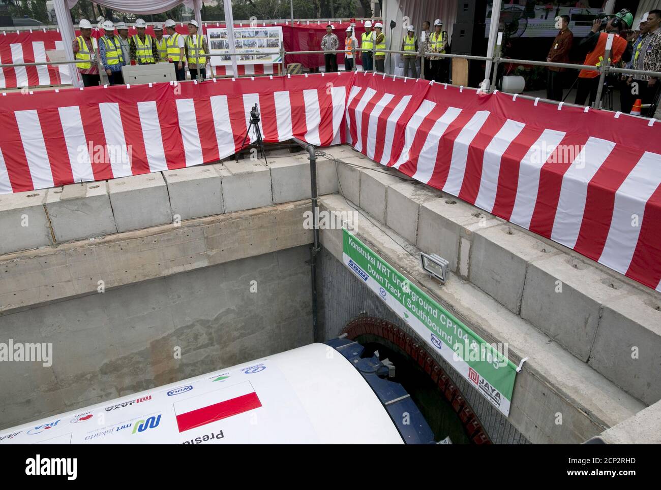 El presidente de Indonesia, Joko Widodo (4th L), empuja una palanca de control hacia adelante para iniciar una máquina de perforación de túneles (abajo) durante una ceremonia en una futura estación para el sistema de tránsito rápido masivo (MRT) en Yakarta, Indonesia, el 21 de septiembre de 2015. El gasto en infraestructura en Indonesia está empezando a repuntar después de largos retrasos, un alivio bienvenido para el plan de Widodo de impulsar la economía más grande del sudeste asiático mediante la construcción de nuevas carreteras, puertos y puentes. REUTERS/Darren Whiteside Foto de stock