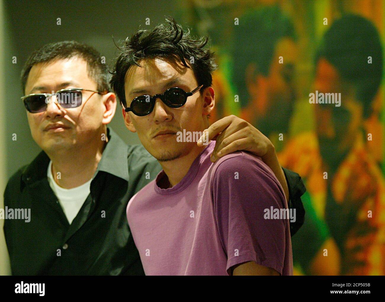 El director de Hong Kong Wong Kar-wai (L) y el actor taiwanés Chang Chen  pose frente a un cartel de la película de 1997 'Happy Together'  protagonizada por Leslie Cheung, en una