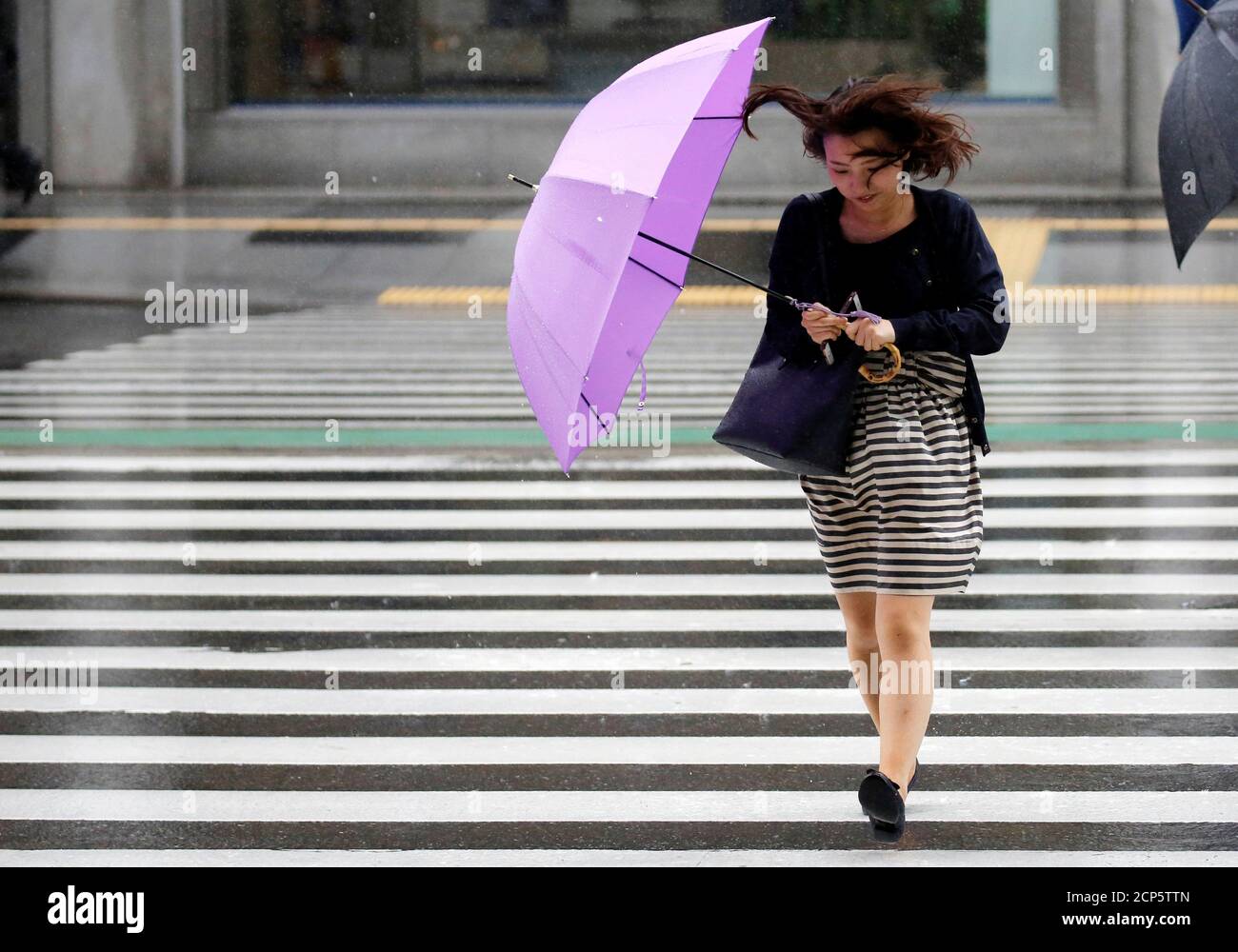 Una mujer que usa un paraguas lucha contra una lluvia pesada y el viento  mientras el tifón Shanshan se acerca al continente japonés en Tokio, Japón  8 de agosto de 2018. REUTERS/Toru