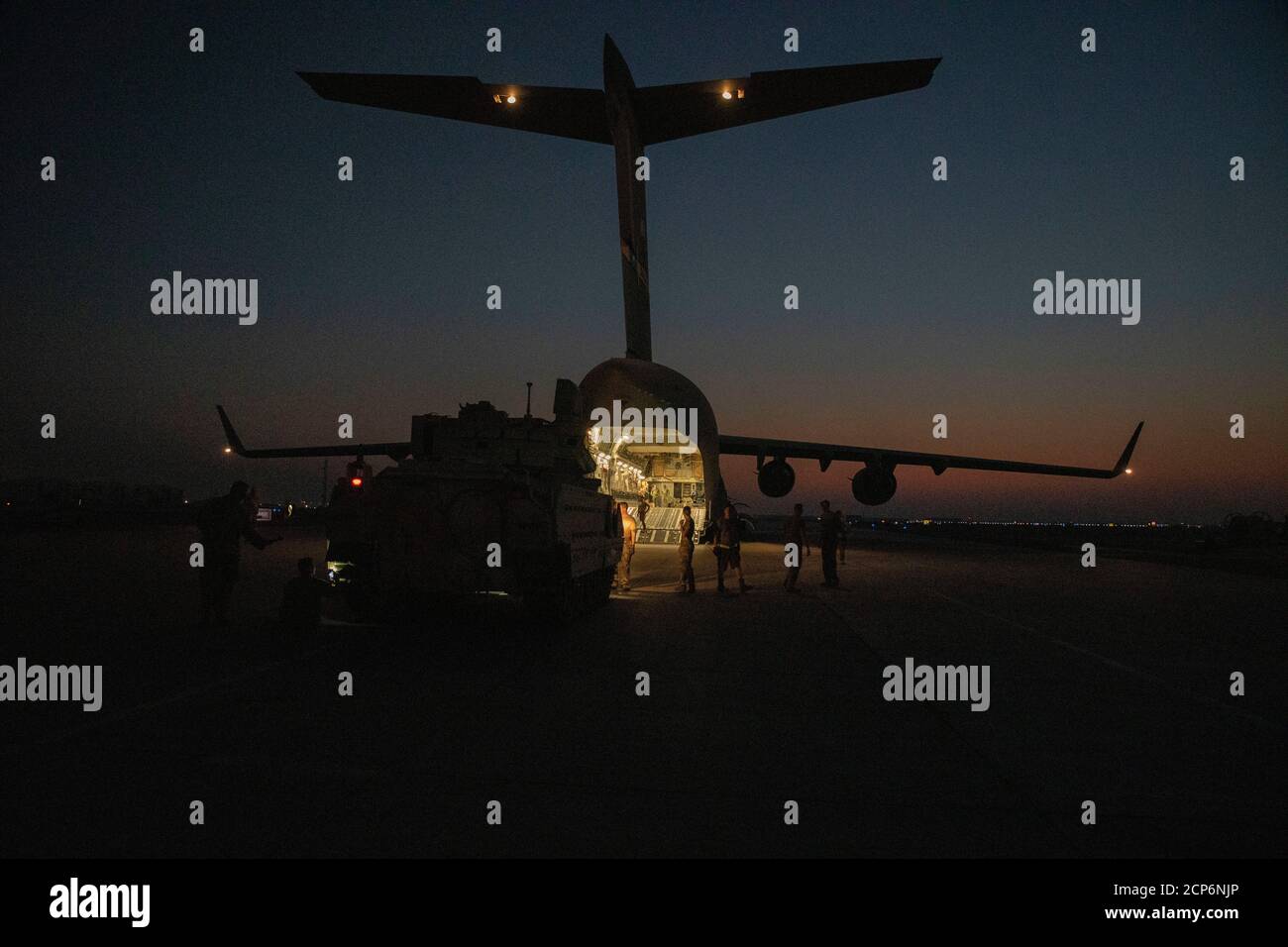 Soldados y aviadores del ejército de EE.UU. Descargan vehículos de combate Bradley de un avión C-17 cerca del noreste de Siria 18 de septiembre de 2020. Los vehículos serán operados por el 1er Batallón, 6o Regimiento de Infantería, 1o soldados de la División blindada durante las operaciones en apoyo de la operación conjunta de Fuerza de tarea inherente (CJTF-OIR). El CJTF-OIR sigue comprometido a trabajar por, con y a través de nuestros socios para asegurar la derrota duradera de Daesh. (EE.UU Foto del ejército por SPC. Jensen Guillory) Foto de stock