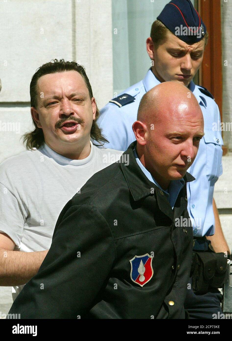 El belga Pascal Teise (R), acusado de pedofilia, está rodeado por agentes  de policía cuando sale de la casa de justicia de NeufChateau en el sur de  Bélgica el 2 de septiembre