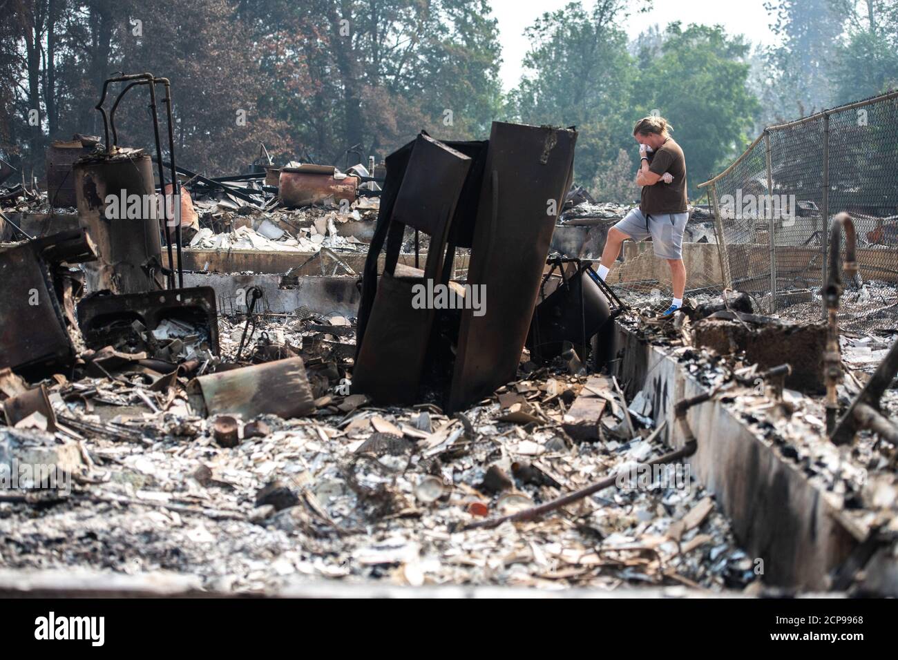 Talent, Oregon 18 Sep, 2020. Zach Kuhlow comprueba los restos de su casa para cualquier cosa salvable. Su hijo, que ahora tiene 10 años, nació dentro de la casa. En Talent, a unas 20 millas al norte de la frontera de California, las casas estaban encantadas más allá del reconocimiento. En todo el oeste de Estados Unidos, al menos 87 incendios forestales están ardiendo, según el National Interagency Fire Center. Han incendiado más de 4.7 millones de acres, más de seis veces el área de Rhode Island. Crédito: Chris Tuite/Image Space/Media Punch/Alamy Live News Foto de stock