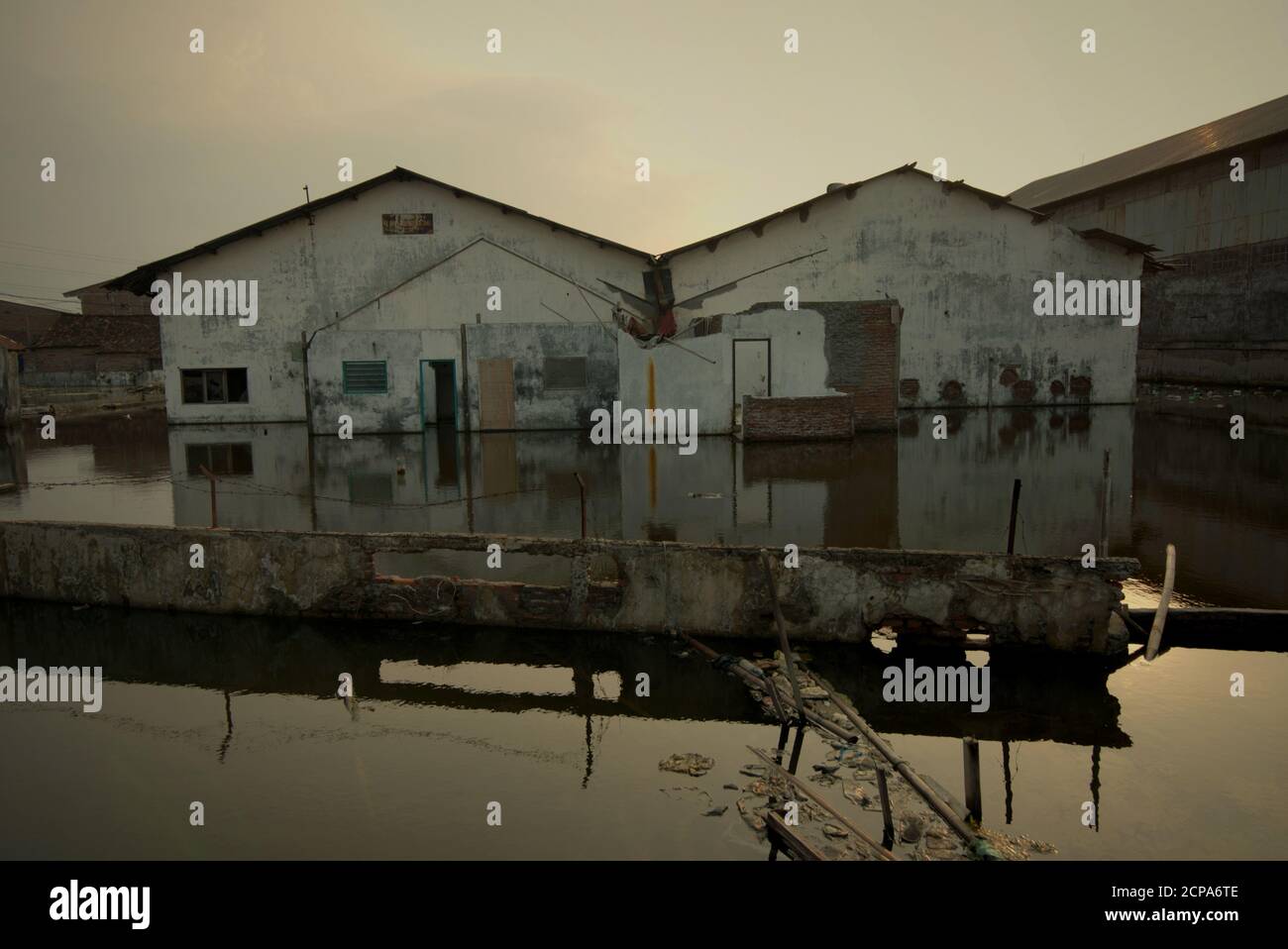 Edificios de almacenes sumergidos en una zona costera que sufren de hundimiento de la tierra e inundaciones de agua de mar. Foto de stock