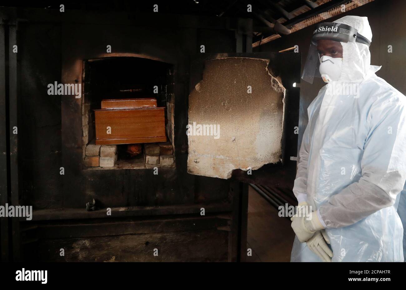 Un trabajador de salud se encuentra junto al ataúd que contiene el cuerpo del Prof. Charles Kariuki que murió a causa de la enfermedad del coronavirus (COVID-19), durante su cremación, en un crematorio en Nairobi, Kenia 20 de julio de 2020. REUTERS/Thomas Mukoya Foto de stock