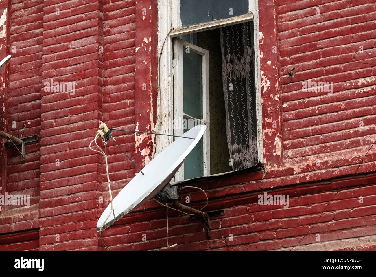 Antena parabólica en la pared de una antigua casa de ladrillo Fotografía de  stock - Alamy