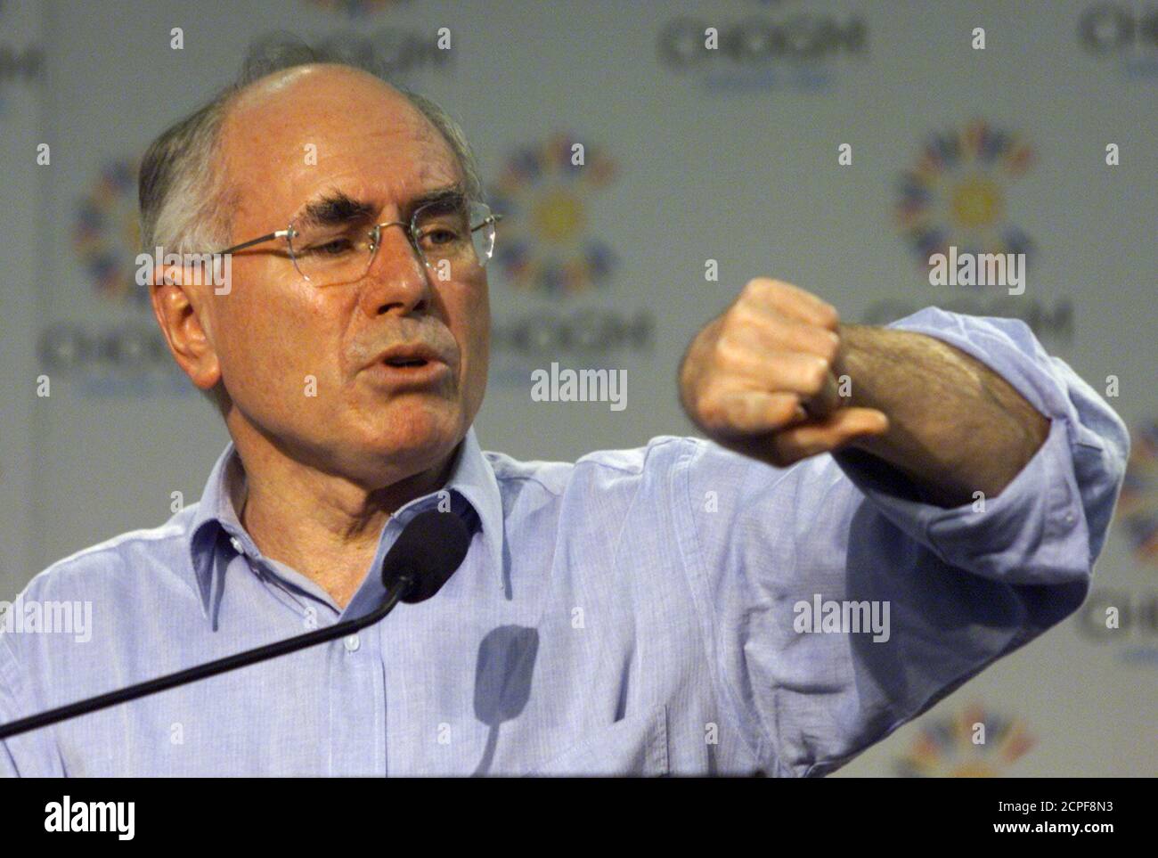 El primer Ministro de Australia, John Howard, mira su reloj durante una conferencia de prensa sobre Zimbabwe en la Reunión de Jefes de Gobierno del Commonwealth (CHOGM) en Coolum el 4 de marzo de 2002. Los líderes del Commonwealth decidieron no tomar medidas inmediatas contra Zimbabwe, sino esperar a que los observadores internacionales informen sobre las elecciones de esta semana. REUTERS/Bob Strong TS/DL Foto de stock