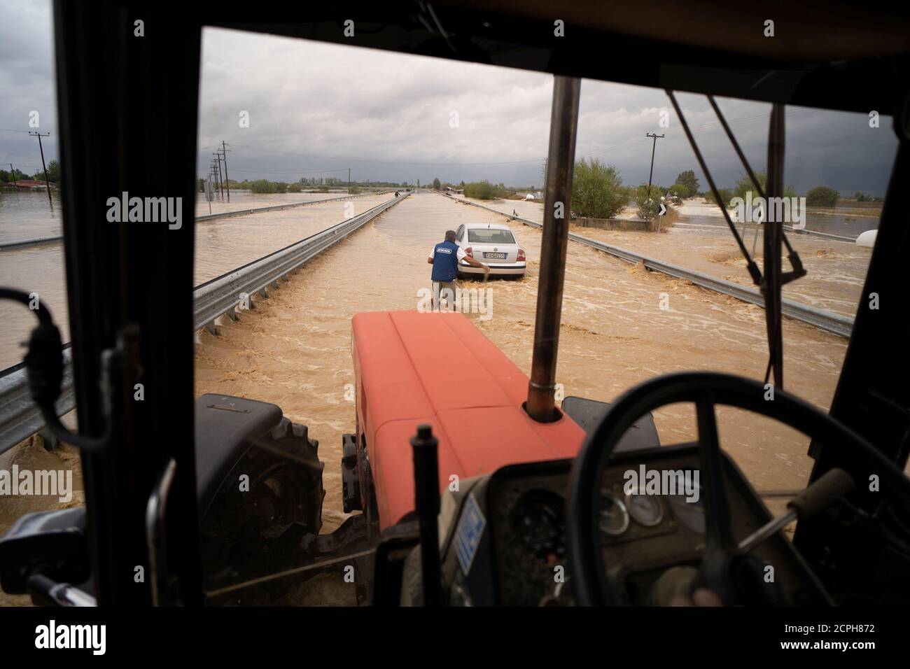 Un local se prepara para remolcar su coche en una carretera inundada después de una tormenta cerca de la aldea de Artesiano, en el centro de Grecia, el 19 de septiembre de 2020. REUTERS/Giannis Floulis Foto de stock