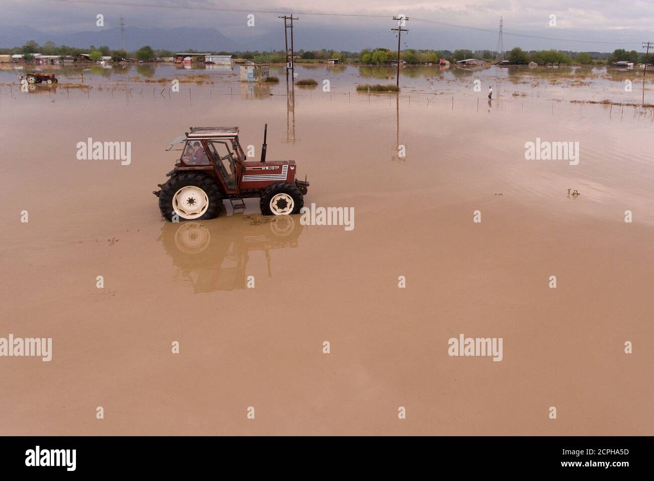 Dos niños son vistos en un tractor en un campo inundado, después de una tormenta cerca de la aldea de Artesiano, en el centro de Grecia, el 19 de septiembre de 2020. Fotografía tomada con un drone. REUTERS/Giannis Floulis Foto de stock