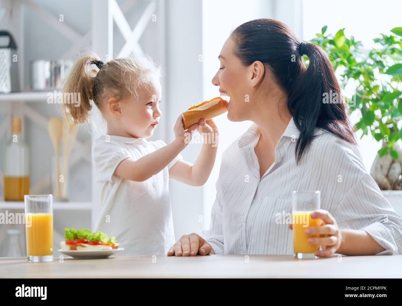 Comida Saludable En Casa Feliz Familia En La Cocina La Madre Y La Hija Están Desayunando 