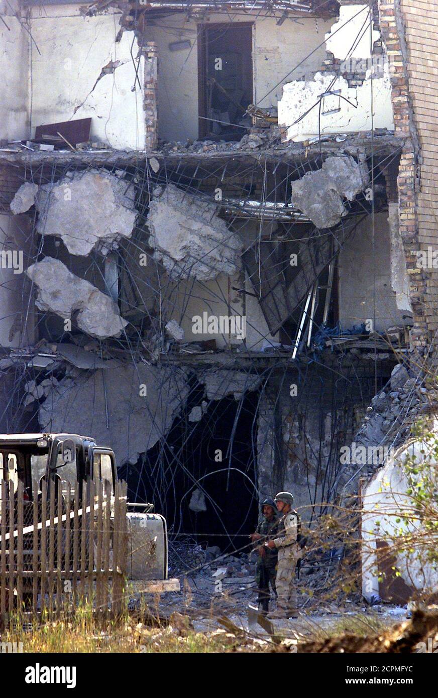 Dos soldados del ejército estadounidense se encuentran cerca de los escombros del edificio de las Naciones Unidas en Bagdad mientras las operaciones de recuperación continúan el 24 de agosto de 2003. La ONU dijo que estaba luchando para identificar cuerpos de iraquíes muertos en una explosión de una bomba de camiones en su sede y pidió a los parientes que se presente con registros dentales y radiografías. REUTERS/Aladin Abdel Naby PA/AA Foto de stock