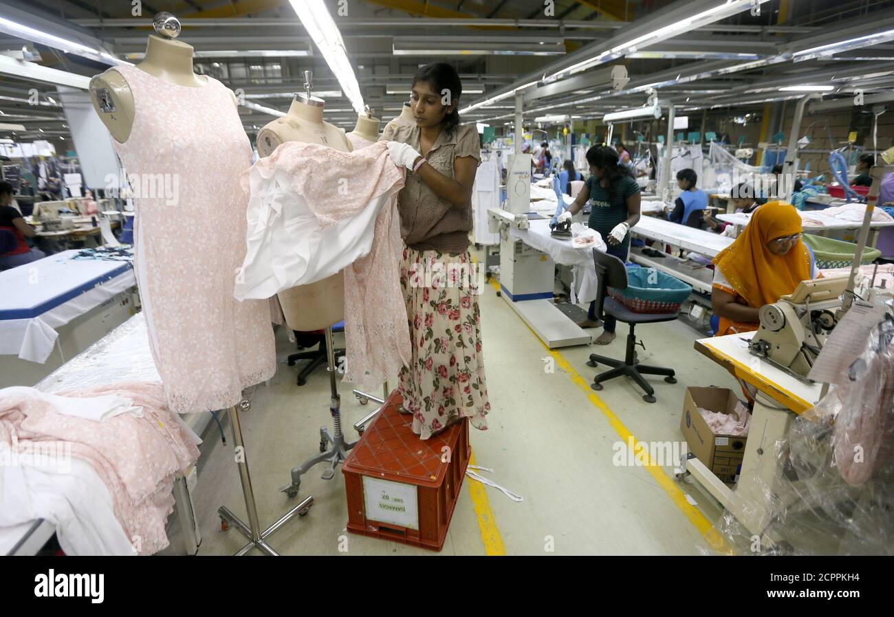 Una mujer ajusta un vestido en un maniquí para su inspección mientras otros trabajadores se sientan vestidos en la fábrica de ropa Timex en Wattala, Sri Lanka, 2 de noviembre de 2017. Una mujer ajusta un vestido en un maniquí para su inspección mientras otros trabajadores se sientan vestidos en la fábrica de ropa Timex en Wattala, Sri Lanka, 2 de noviembre de 2017.