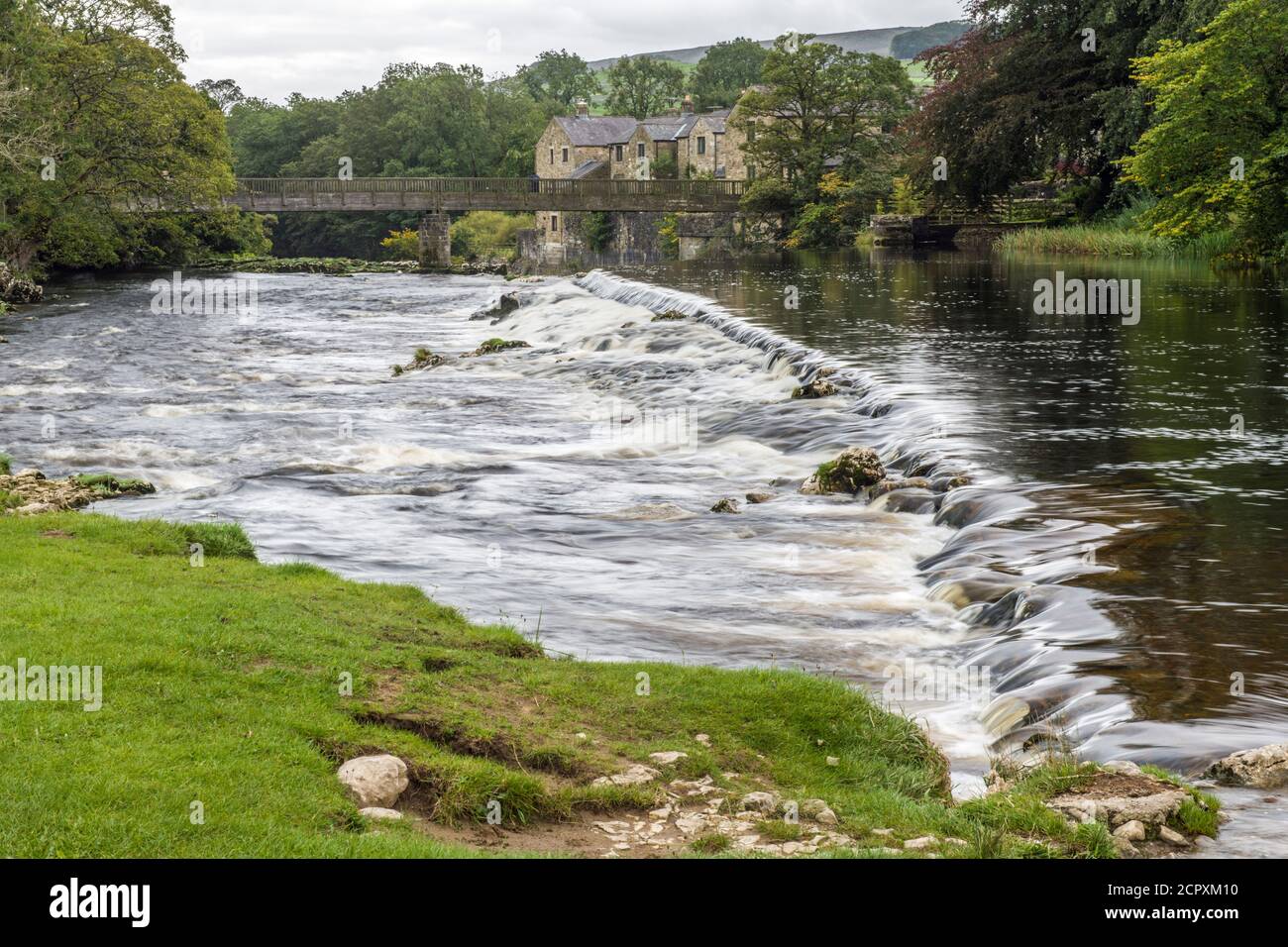 Weir en el río Wharfe sobre Linton Falls, Grassington, después de una ducha de lluvia. Hay dos llores, este es el más bajo. Wharfedale en los cuentos de Yorks Foto de stock