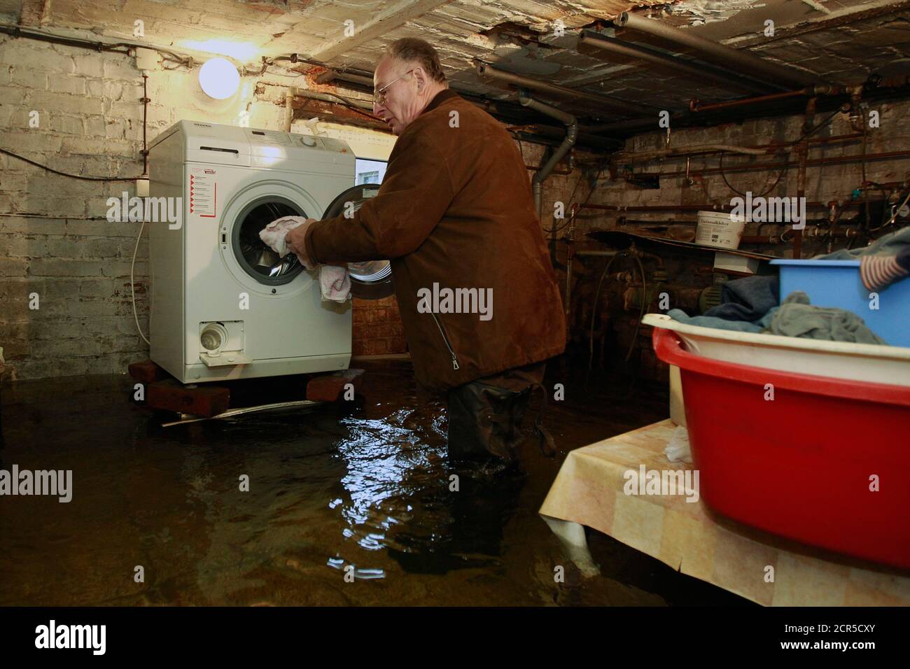 Hans-Adolf Fakler loads his washing machine in his flooded basement after  ground water broke in, at the village of Golzow near the Polish border,  January 18, 201. Many field and basements in