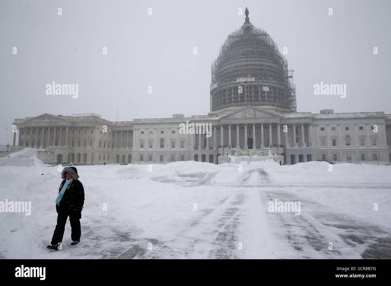 Una persona camina por los terrenos cubiertos de nieve del Capitolio de los Estados Unidos en Washington el 23 de enero de 2016. El sábado, la gruesa nieve cubrió el área de Washington, D.C. como una carretera paralizada, ferrocarril y aerolínea potencialmente sin precedentes en la costa este de Estados Unidos, desde Carolina del Norte hasta Nueva York. REUTERS/Jonathan Ernst Foto de stock