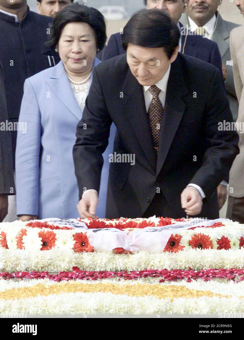 El primer ministro chino Zhu Rongji (R) ajusta la bufanda en una corona en el memorial Mahatma Gandhi en Rajghat, Nueva Delhi, el 14 de enero de 2002, mientras su esposa, la señora Lao An, mira. Zhu, el primer premier chino que visitó la India desde diciembre de 1991, ha pedido públicamente a Pakistán que muestre "máxima moderación" y es probable que presente el mismo mensaje a la India durante su visita de seis días. REUTERS/Kamal Kishore PK/DL Foto de stock