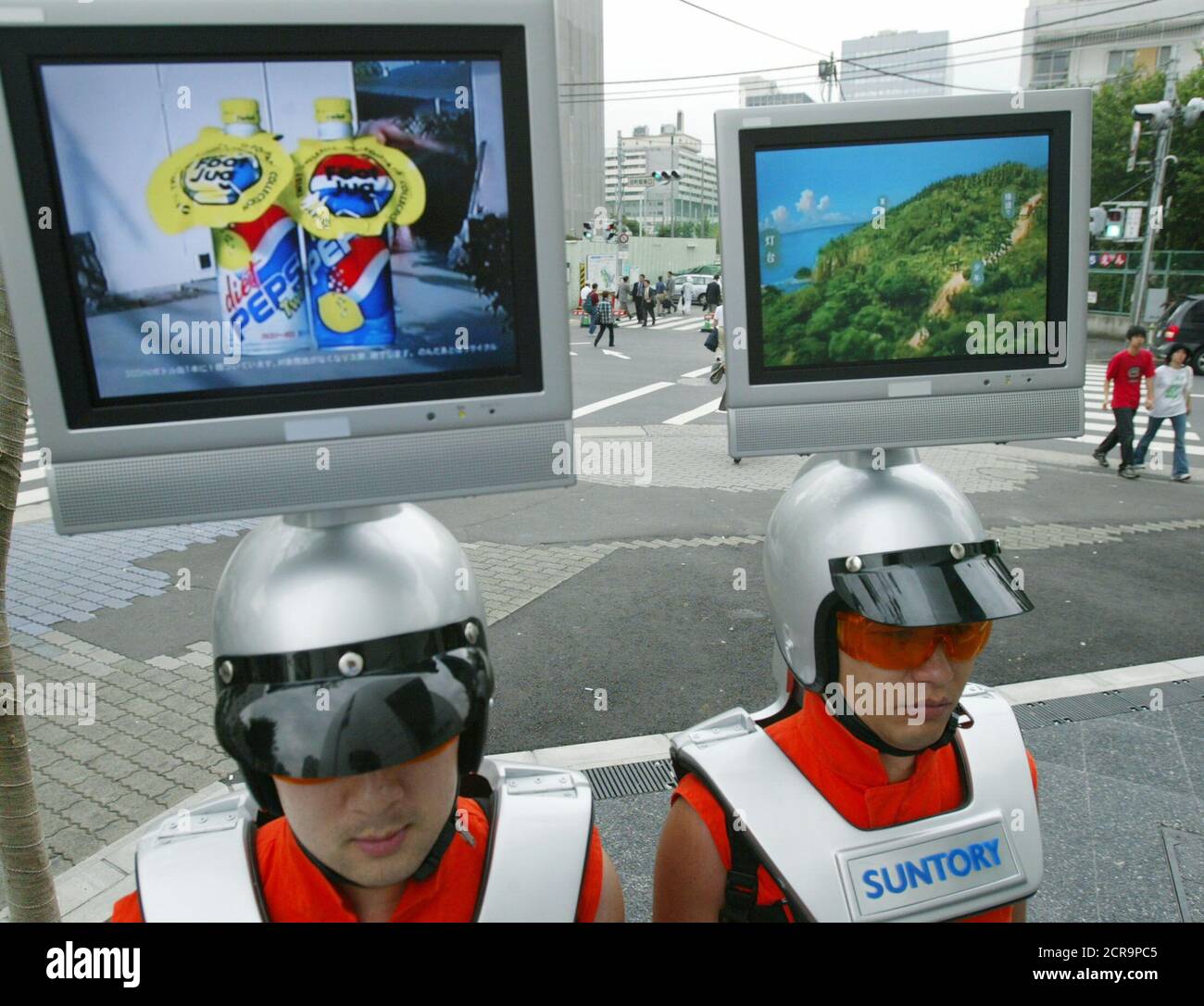 Los empleados de la empresa japonesa de publicidad llevan "cascos de  televisión" mostrando anuncios de televisión mientras caminan por el centro  de Tokio 9 de julio de 2003. La empresa japonesa Suntory