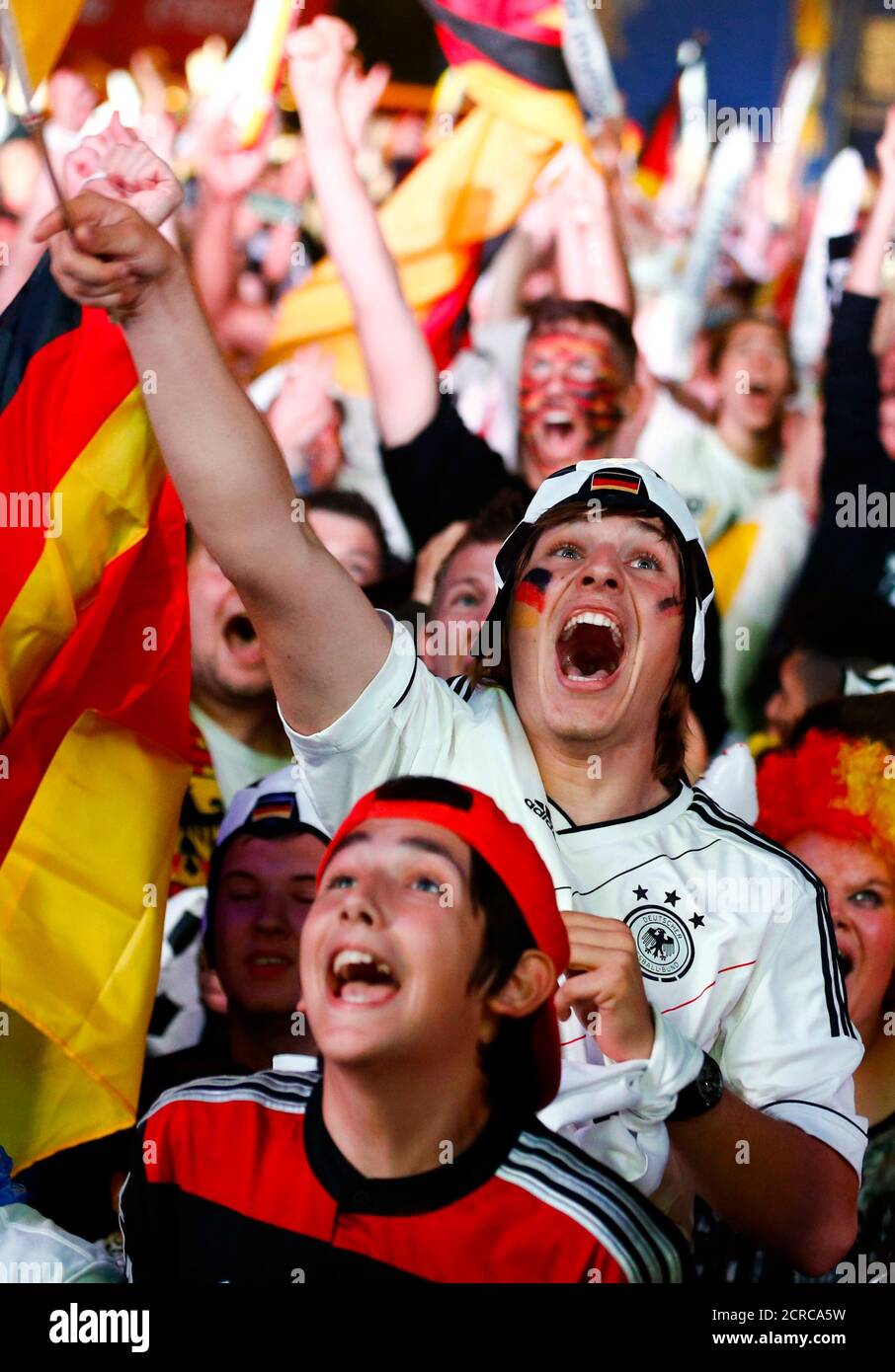 La gente celebra después de que Alemania anotó contra Brasil durante sus semifinales de la Copa del Mundo 2014, en el Fanmeile público que ve arena en Berlín el 8 de julio de 2014. REUTERS/Thomas Peter (ALEMANIA - Tags: FÚTBOL DEPORTE COPA DEL MUNDO) Foto de stock
