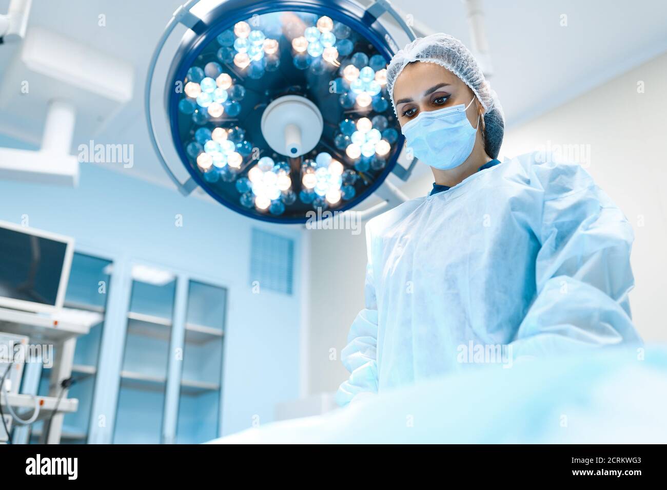 Cirujano femenino en bata y máscara en Fotografía de stock -