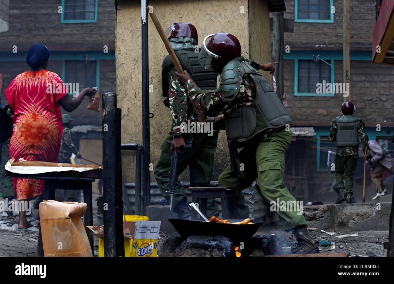 Los residentes huyen mientras los policías antidisturbios se despliegan para dispersar a los manifestantes que apoyan al líder de la oposición Raila Odinga en Mathare, Nairobi, Kenia, 12 de agosto de 2017. REUTERS/Thomas Mukoya Foto de stock