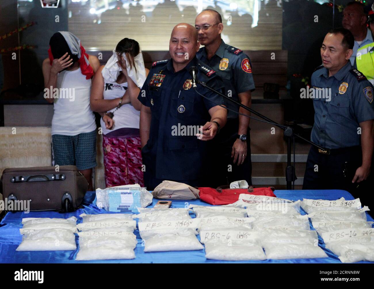 Philippine National Police (PNP) chief Dir. Gen. Ronald 'Bato' Dela Rosa  (C) gestures as he presents the two suspected drug pushers who were  arrested for seized Methamphetamine, locally known as Shabu, worth
