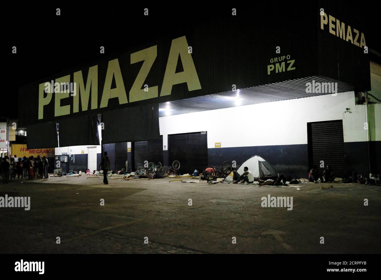 Los venezolanos descansan durante la noche en una tienda de repuestos para  autos y motos, cerca de la estación de autobuses interestatal en Boa Vista,  estado de Roraima, Brasil 24 de agosto