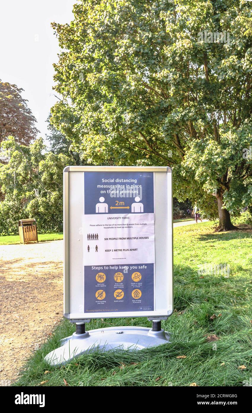Reglas de distanciamiento social y consejos de salud pública exhibidos en Oxford University Parks, Oxford, Reino Unido Foto de stock