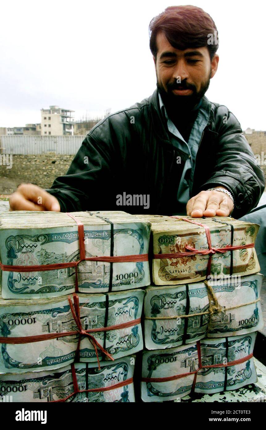 Un comerciante de dinero afgano cuenta billetes de 10,000 afganos en el mercado de dinero al aire libre 'Shahzada' en Kabul el 18 de febrero de 2002. REUTERS/Mario Laporta ML Foto de stock