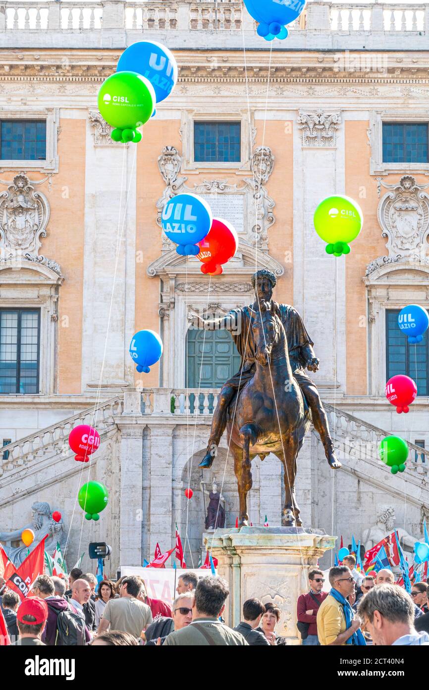 Roma Italia Estatua ecuestre del Emperador Marcus Aurelius en la Piazza del Campidoglio Colina Capitolina frente al Ayuntamiento Romano con manifestantes sindicales. Foto de stock