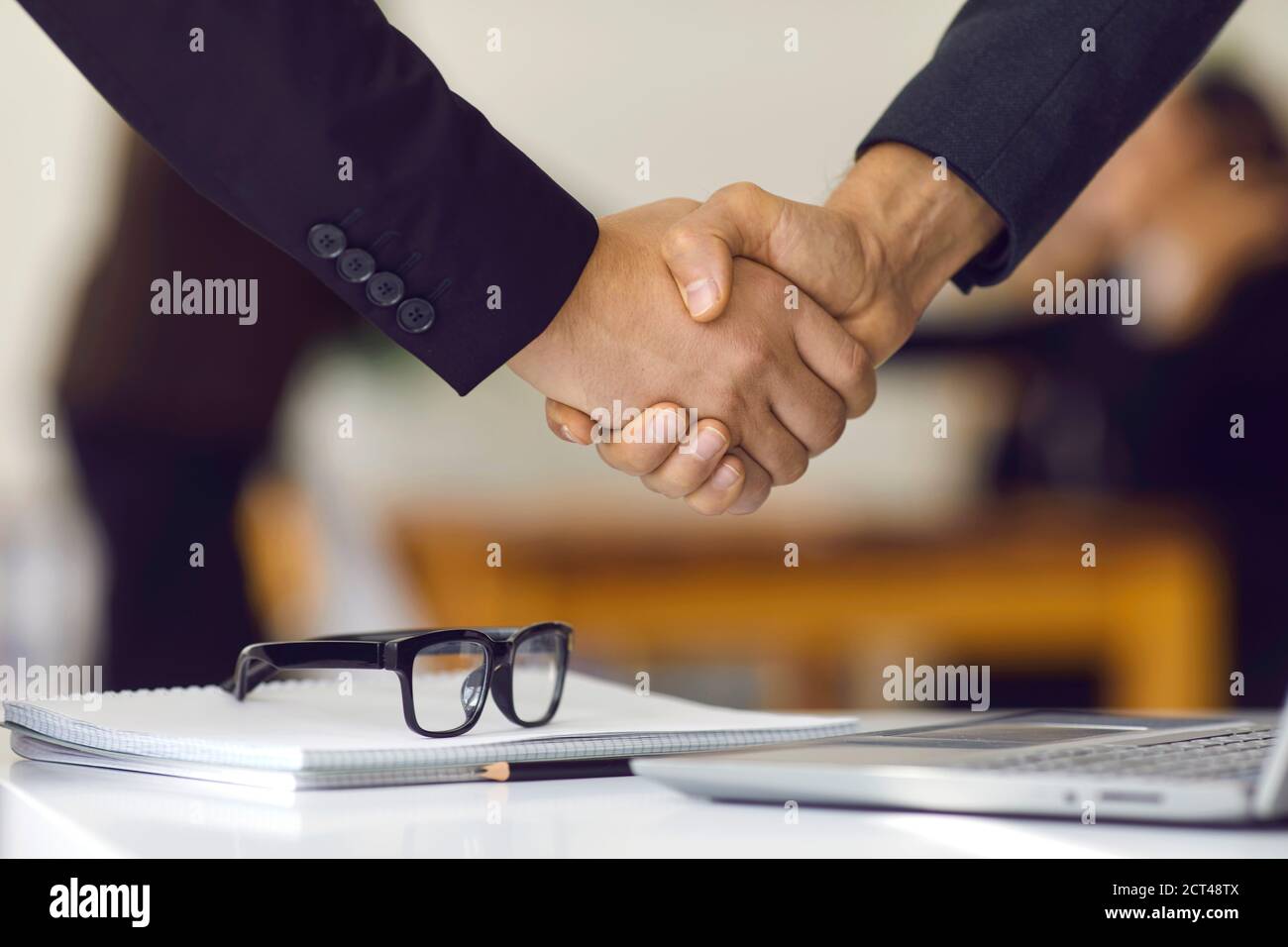 Primer plano de socios de negocios que se agitan manos haciendo acuerdos y confirmando colaboración Foto de stock