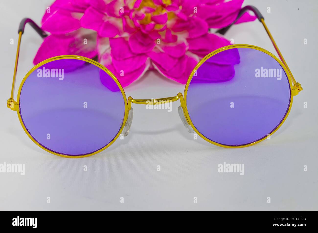 ola ala Inútil Gafas de sol hippie Chic. Imagen de stock. Gafas de sol redondas con un  cristal púrpura, marco dorado y flor rosa. Aislado sobre fondo blanco  Fotografía de stock - Alamy